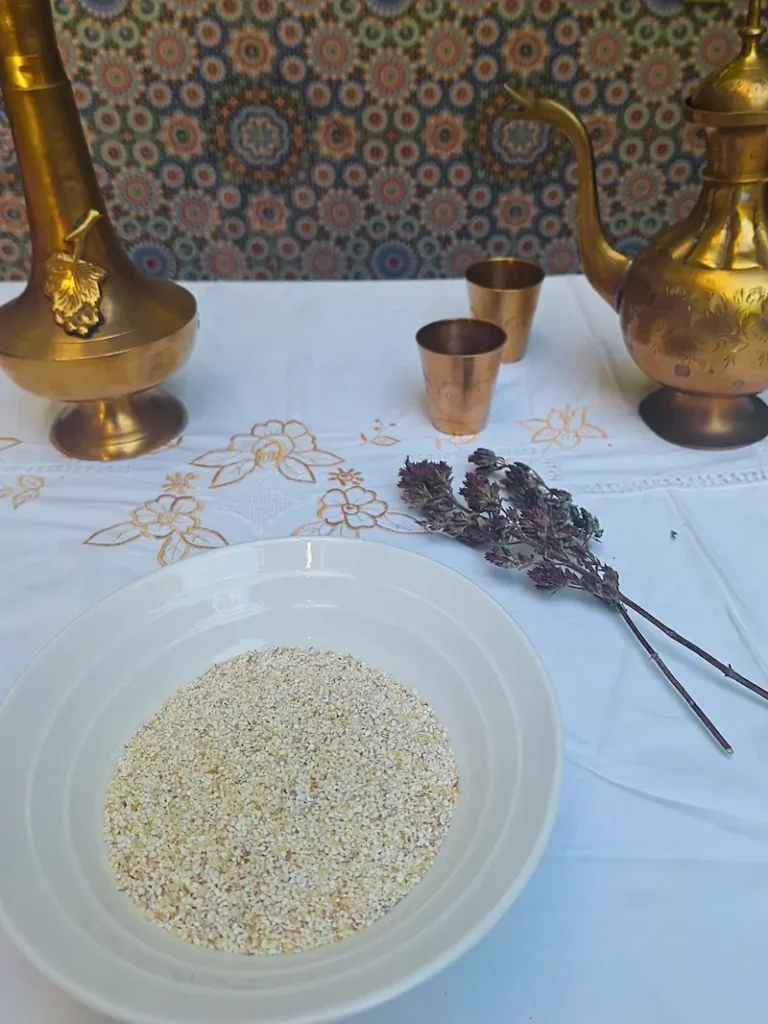 Raw barley grits (Belboula) in a bowl, showing the cracked grain texture needed.