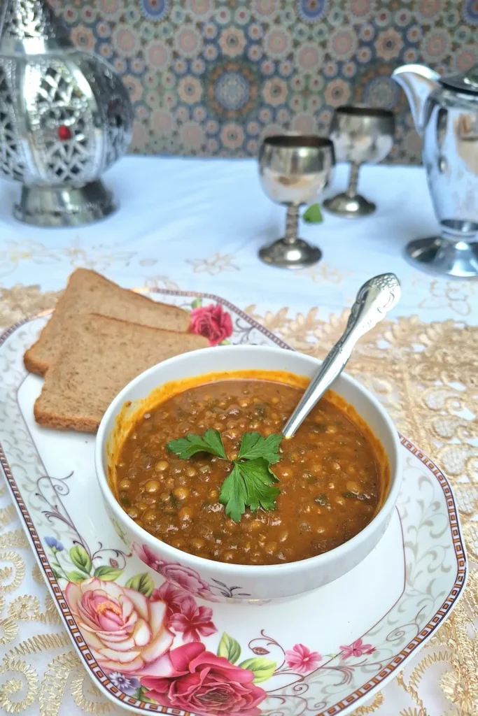Vertical Pinterest pin showing a close-up of a steaming bowl of One-Pot Moroccan Lentils with bread on a cozy tray, highlighting a quick 30-minute vegan dinner recipe.